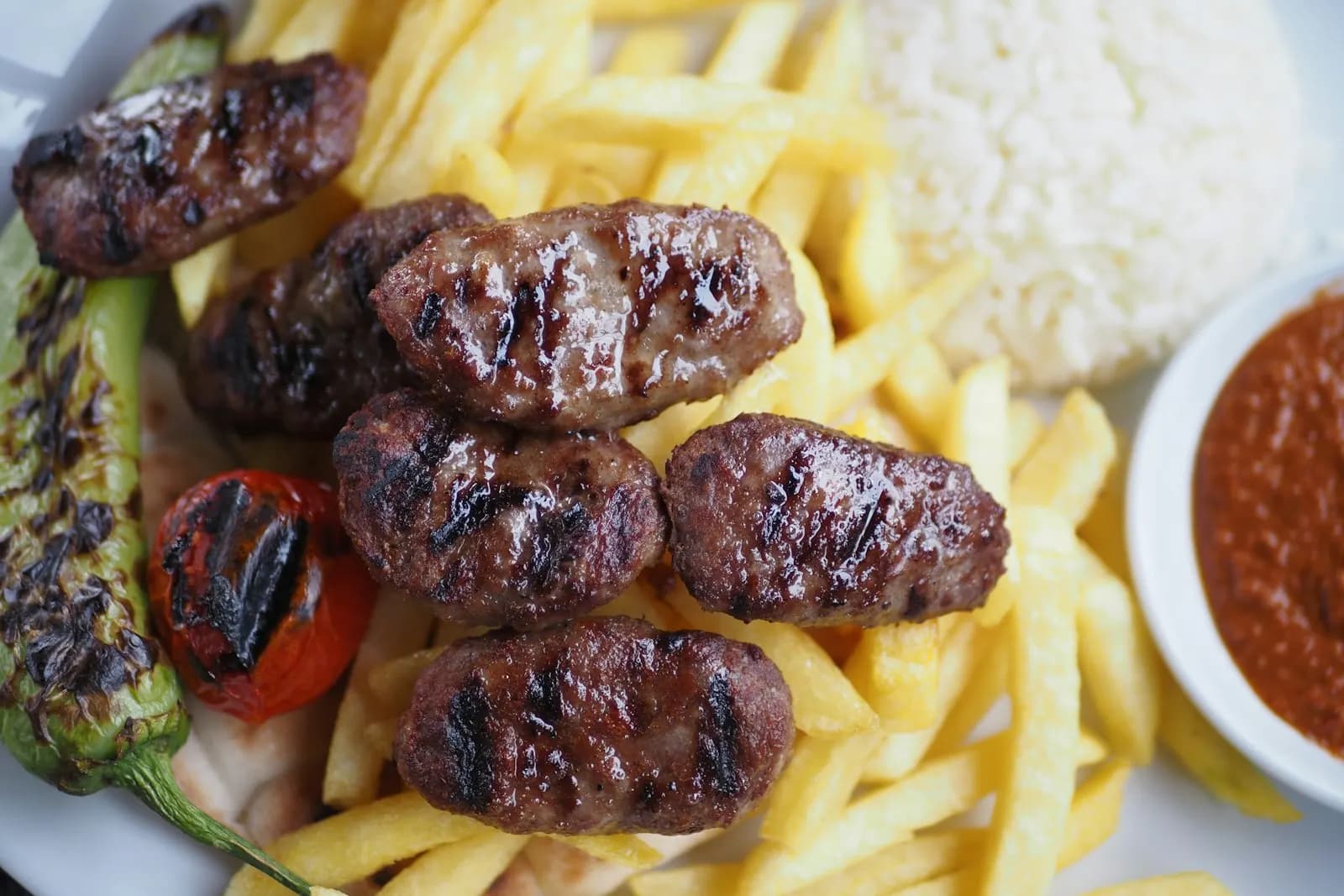 كفتة مشوية مع بطاطس مقلية وأرز أبيض وفلفل وطماطم مشوية