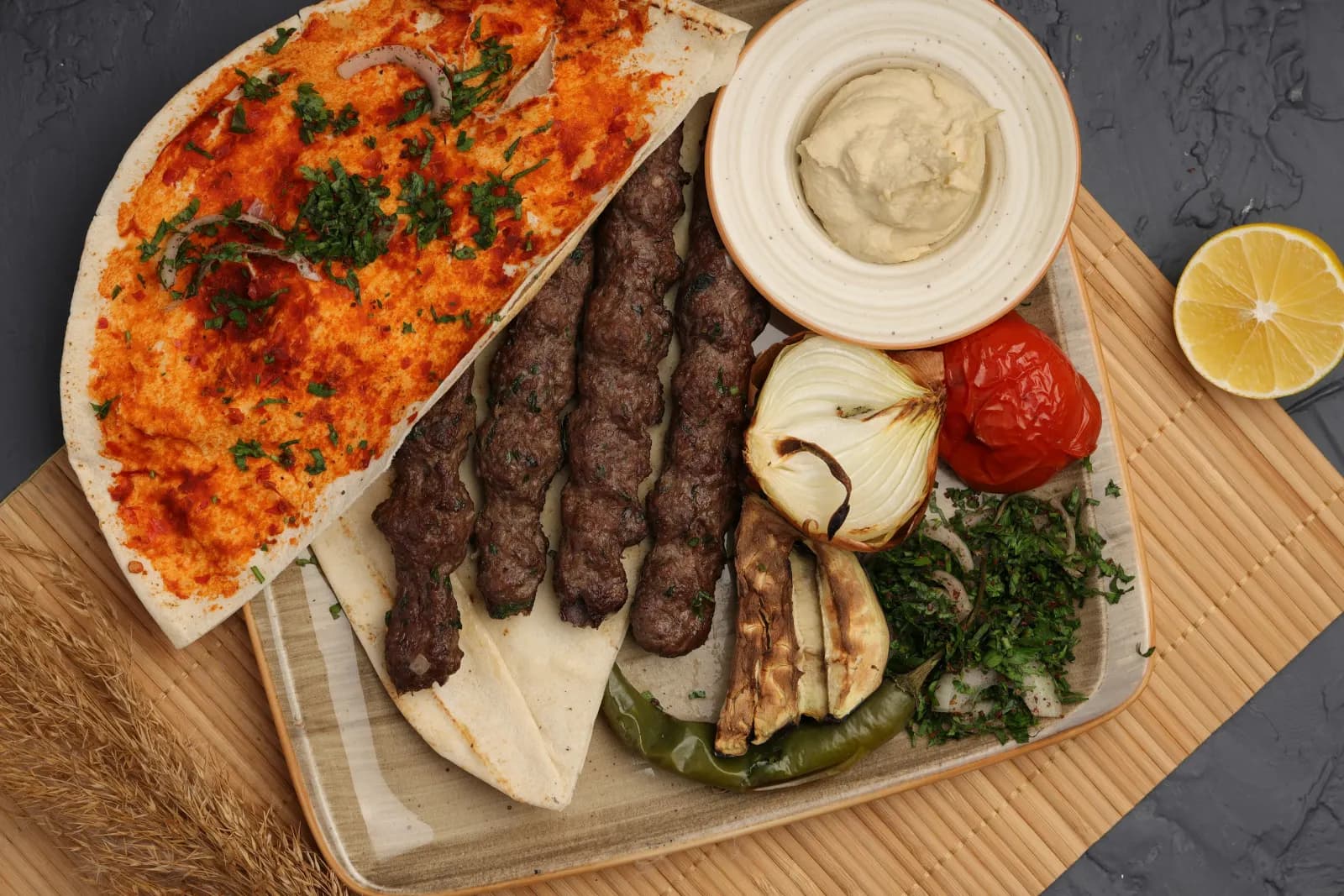 أسياخ كباب مشوية مع خبز وحمص وبصل وطماطم مشوية