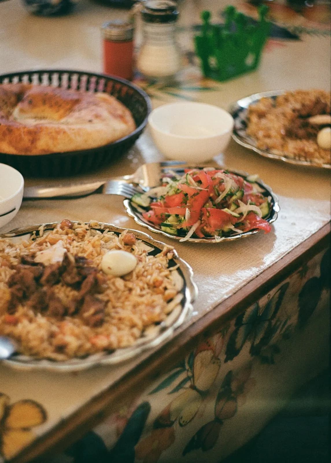 طاولة مطعم عليها صحون أرز باللحم وسلطة وخبز